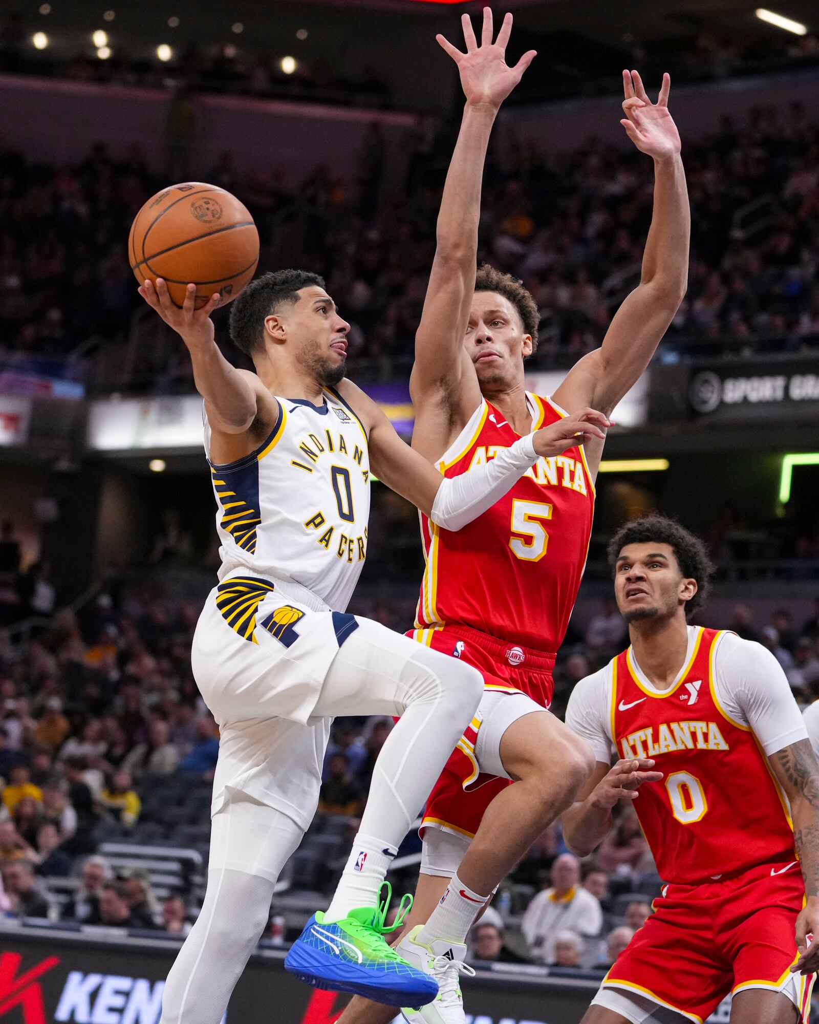 Indiana Pacers guard Tyrese Haliburton (0) shoots over Atlanta Hawks guard Dyson Daniels (5) during the second half of an NBA basketball game in Indianapolis, Saturday, Feb. 1, 2025. (AP Photo/Michael Conroy)