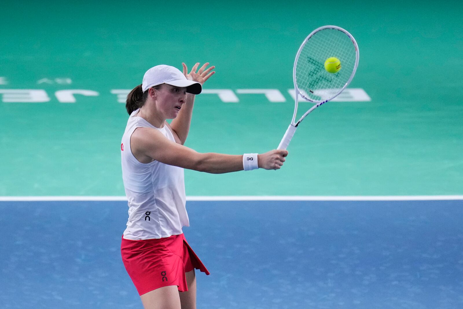 Poland's Iga Swiatek returns the ball against Italy's Jasmine Paolini during the Billie Jean King Cup semi-final tennis match at Martin Carpena Sports Hall in Malaga, southern Spain, on Monday, Nov. 18, 2024. (AP Photo/Manu Fernandez)