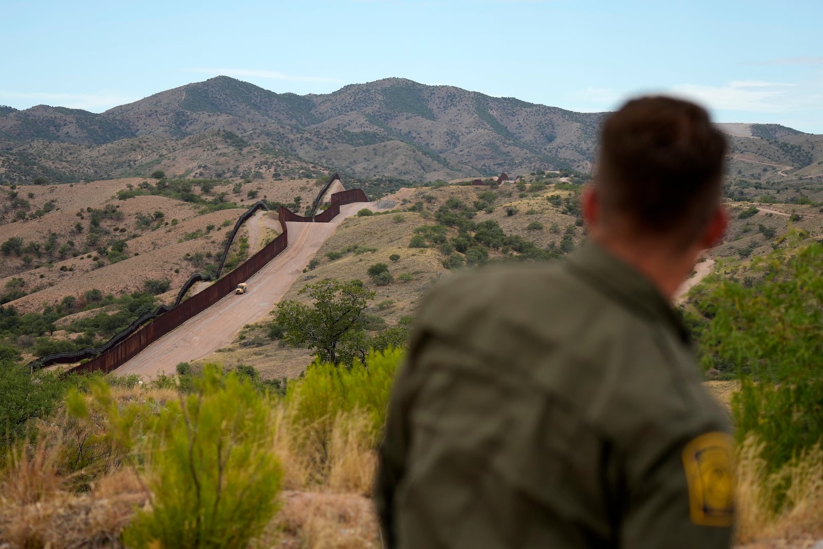 FILE - Border patrol agent Pete Bidegain looks from a hilltop on the U.S. side of the US-Mexico border in Nogales, Ariz., June 25, 2024. (AP Photo/Jae C. Hong, Pool, File)