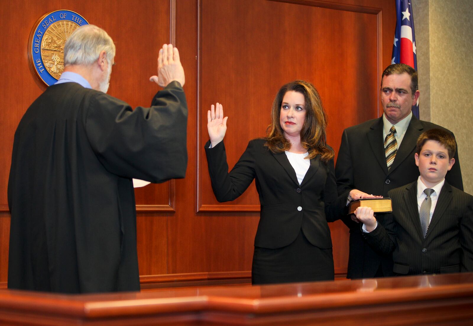 Former Assistant Butler County Prosecutor Jennifer Muench-McElfresh accompanied by her husband Robert McElfresh and son Zachary McElfresh, was given the oath of office as Butler County Common Pleas Judge by Judge H.J. Bressler, (retired) during a ceremony at the Butler County Government Services Center, Monday, Oct. 21, 2013. GREG LYNCH / STAFF