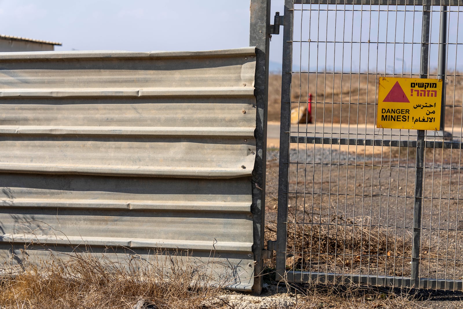 A sign warning of mines hangs on a gate in the tiny settlement of "Trump Heights" in the Israeli-controlled Golan Heights, where Israeli residents are welcoming the election of their namesake. They hope Donald Trump's return to the U.S. presidency will breathe new life into the community. Thursday, Nov. 7, 2024. (AP Photo/Ariel Schalit)