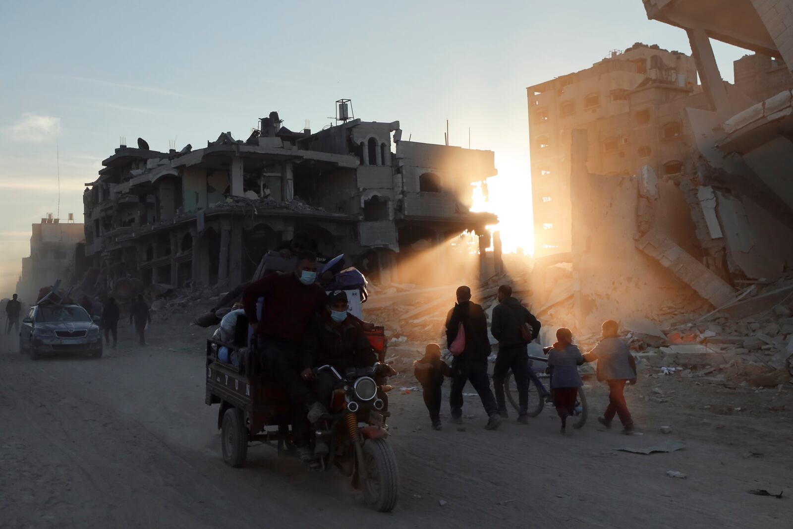 Palestinians walk through the destruction caused by the Israeli air and ground offensive in Jabaliya, a day after the ceasefire deal between Israel and Hamas came into effect, Monday, Jan. 20, 2025. (AP Photo/Abed Hajjar)