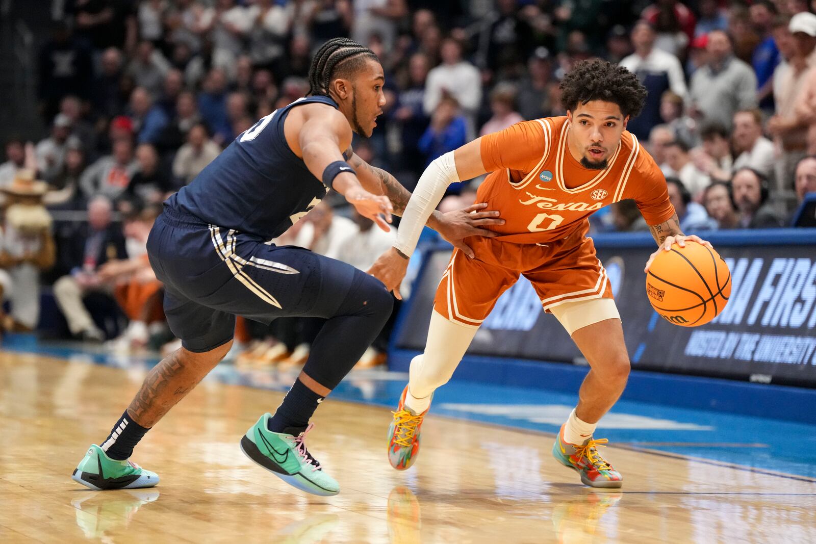 Texas guard Jordan Pope (0) drives against Xavier guard Dayvion McKnight during the first half of a First Four college basketball game in the NCAA Tournament, Wednesday, March 19, 2025, in Dayton, Ohio. (AP Photo/Jeff Dean)