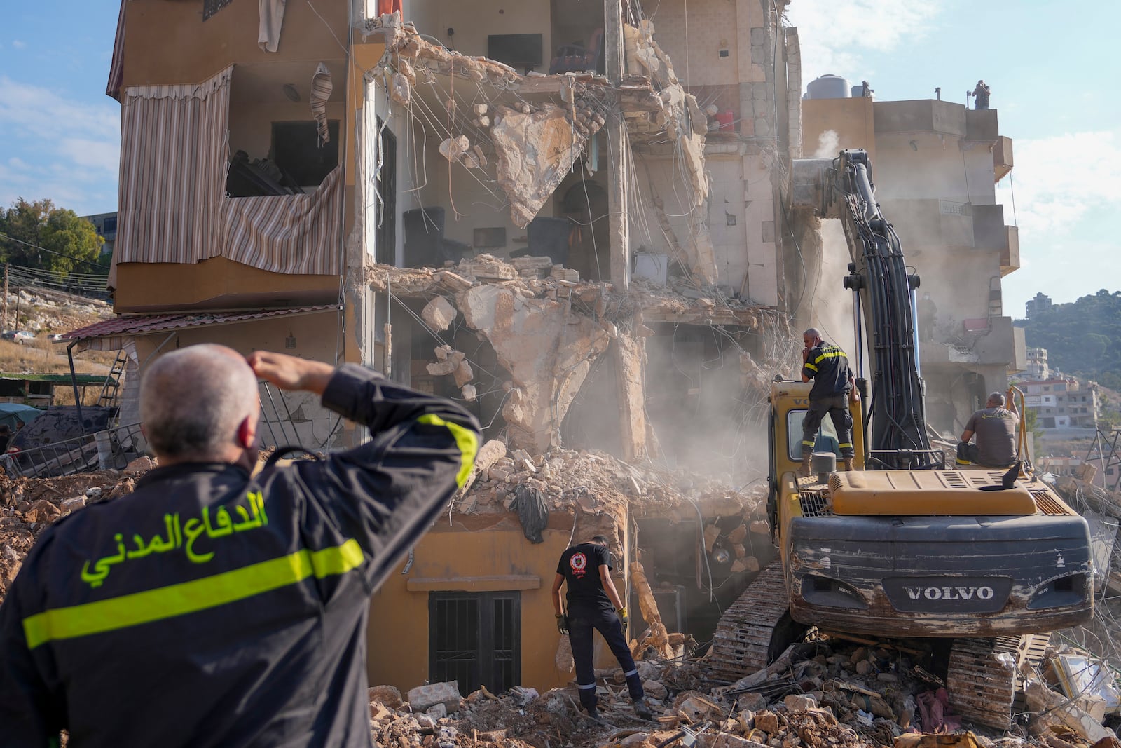 Rescue workers use an excavator to remove the rubble of a destroyed building that was hit Tuesday night in an Israeli airstrike, as they search for victims in Barja, Lebanon, Wednesday, Nov. 6, 2024. (AP Photo/Hassan Ammar)