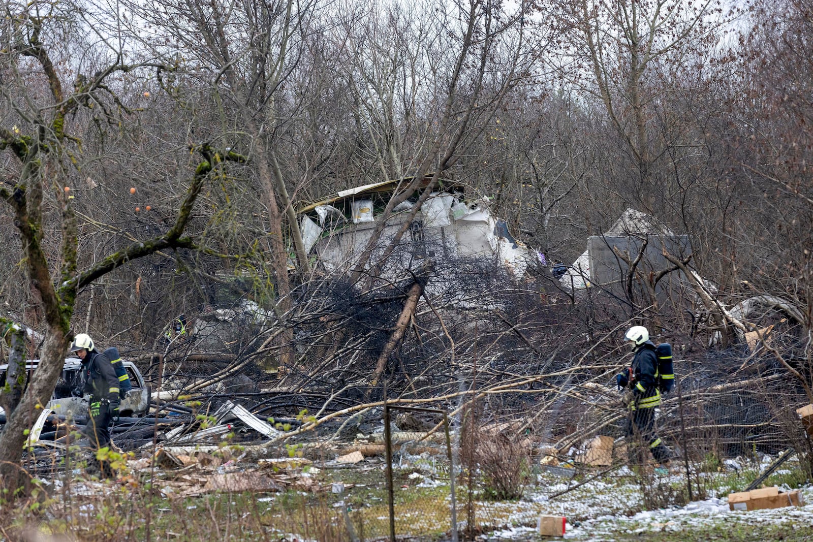 Lithuanian Emergency Ministry employees work near the site where a DHL cargo plane crashed into a house near the Lithuanian capital Vilnius, Lithuania, Lithuania, Monday, Nov. 25, 2024. (AP Photo/Mindaugas Kulbis)