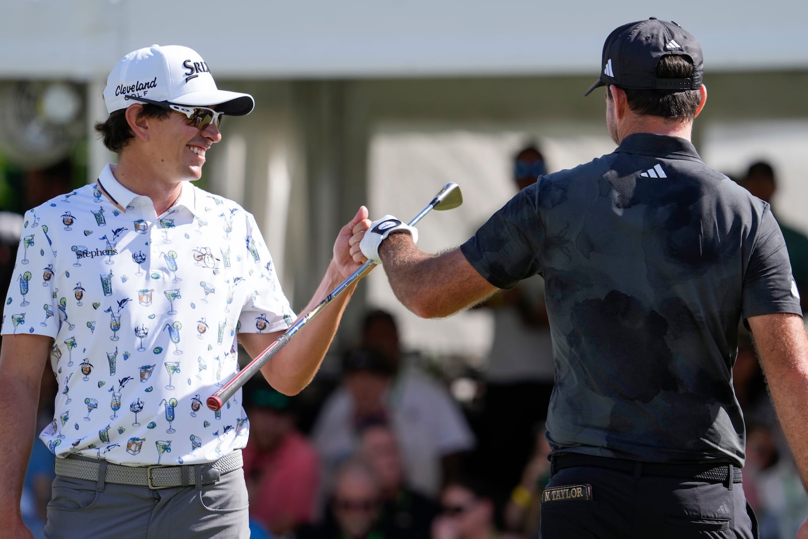 Nico Echavarria, left, of Columbia, greets Nick Taylor, of Canada, after Taylor made a shot on the 18th green during the final round of the Sony Open golf event, Sunday, Jan. 12, 2025, at Waialae Country Club in Honolulu. (AP Photo/Matt York)