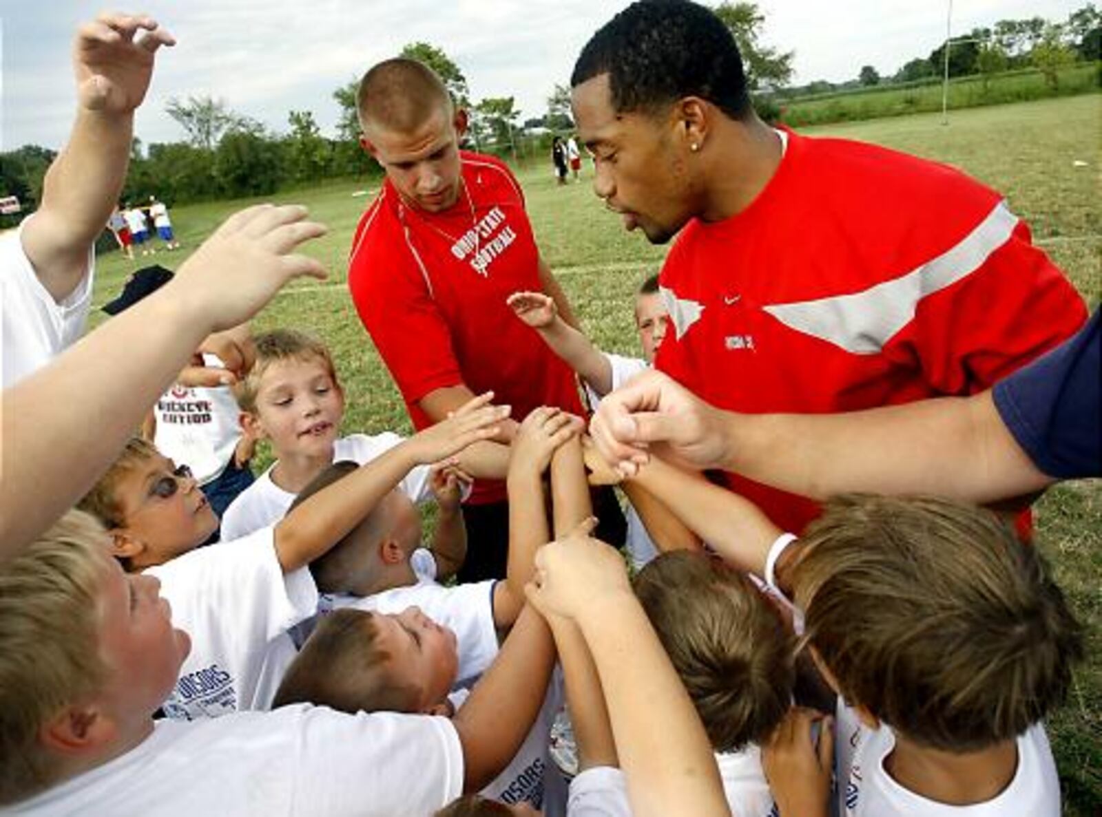 Ohio State football players James Laurinaitis and Marcus Freeman lead a group of first, second, and third-graders in a cheer after leading a series of drills during a pee wee football camp Wednesday evening at Northwestern High School.