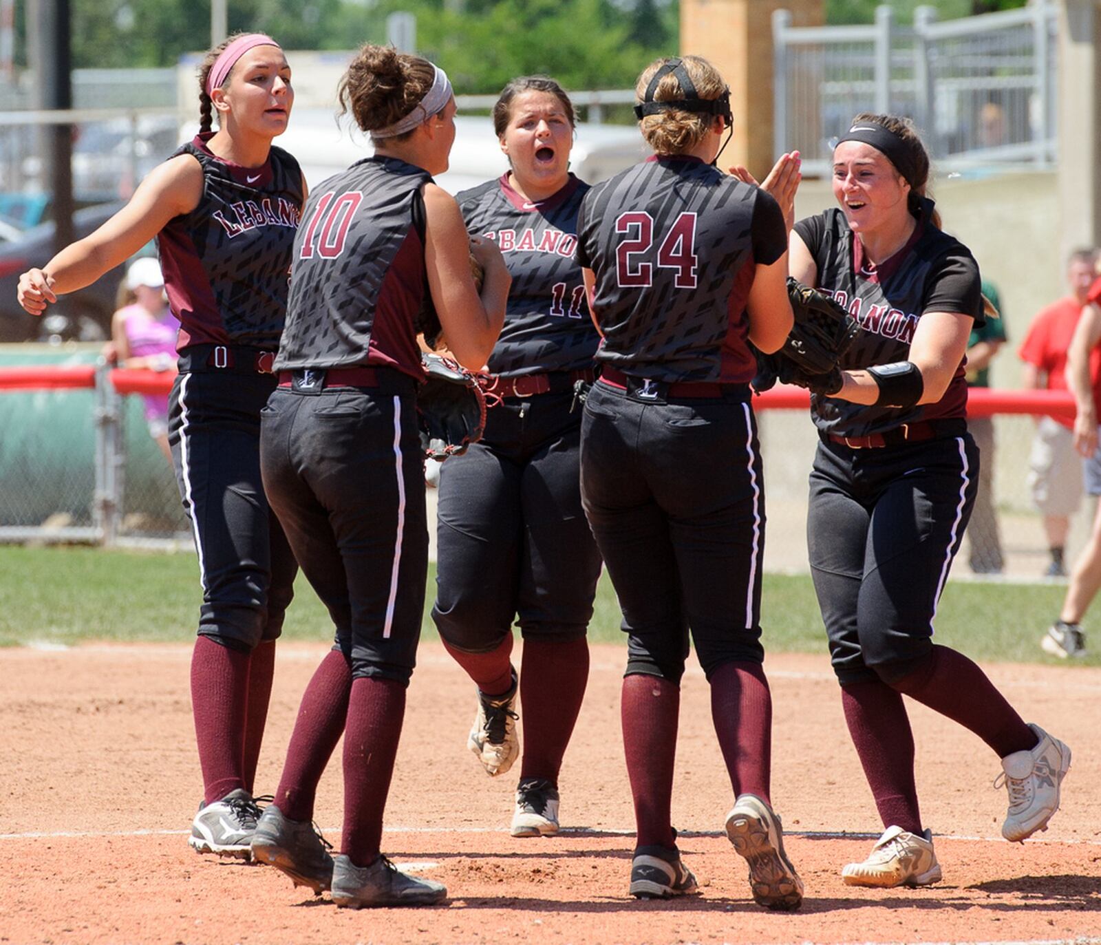 Lebanon’s infielders celebrate with pitcher Taylor Lewis (right) after recording an out in the seventh inning Saturday during the Division I state final against Elyria at Firestone Stadium in Akron. The infielders are Alex Gibson (24), Ashley West (10), Alexis Strother (11) and Madison Hartman. CONTRIBUTED PHOTO BY BRYANT BILLING