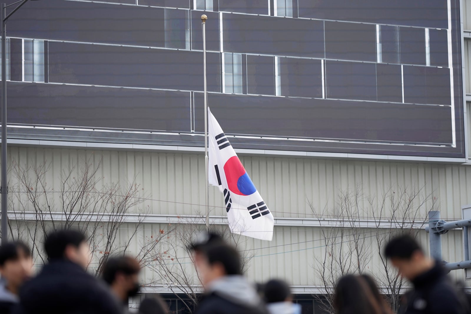 A South Korean national flag flies at half-staff in downtown Seoul, South Korea, Monday, Dec. 30, 2024, a day after a jetliner skidded off a runway, slammed into a concrete fence and burst into flames at an airport the town of Muan. (AP Photo/Lee Jin-man)