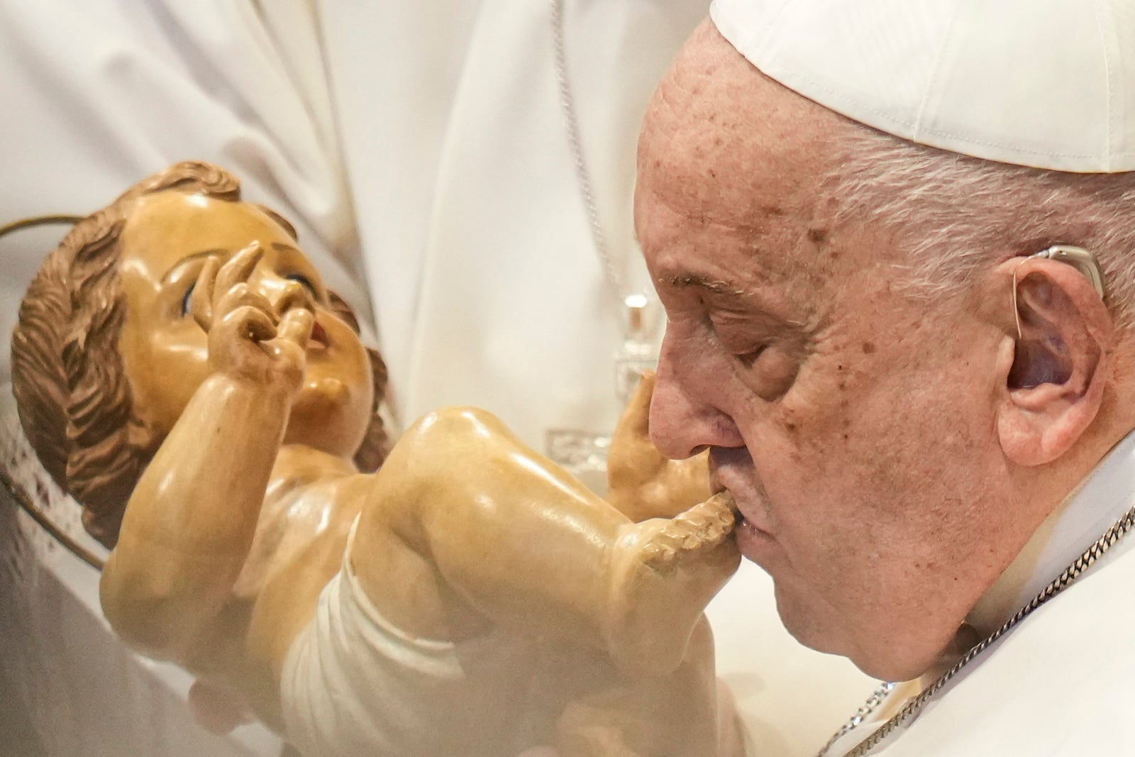 Pope Francis kisses a wooden statuette of the infant Jesus at the end of a mass in St. Peter's Basilica at The Vatican on New Year's Day, Wednesday, Jan. 1, 2025. (AP Photo/Andrew Medichini)