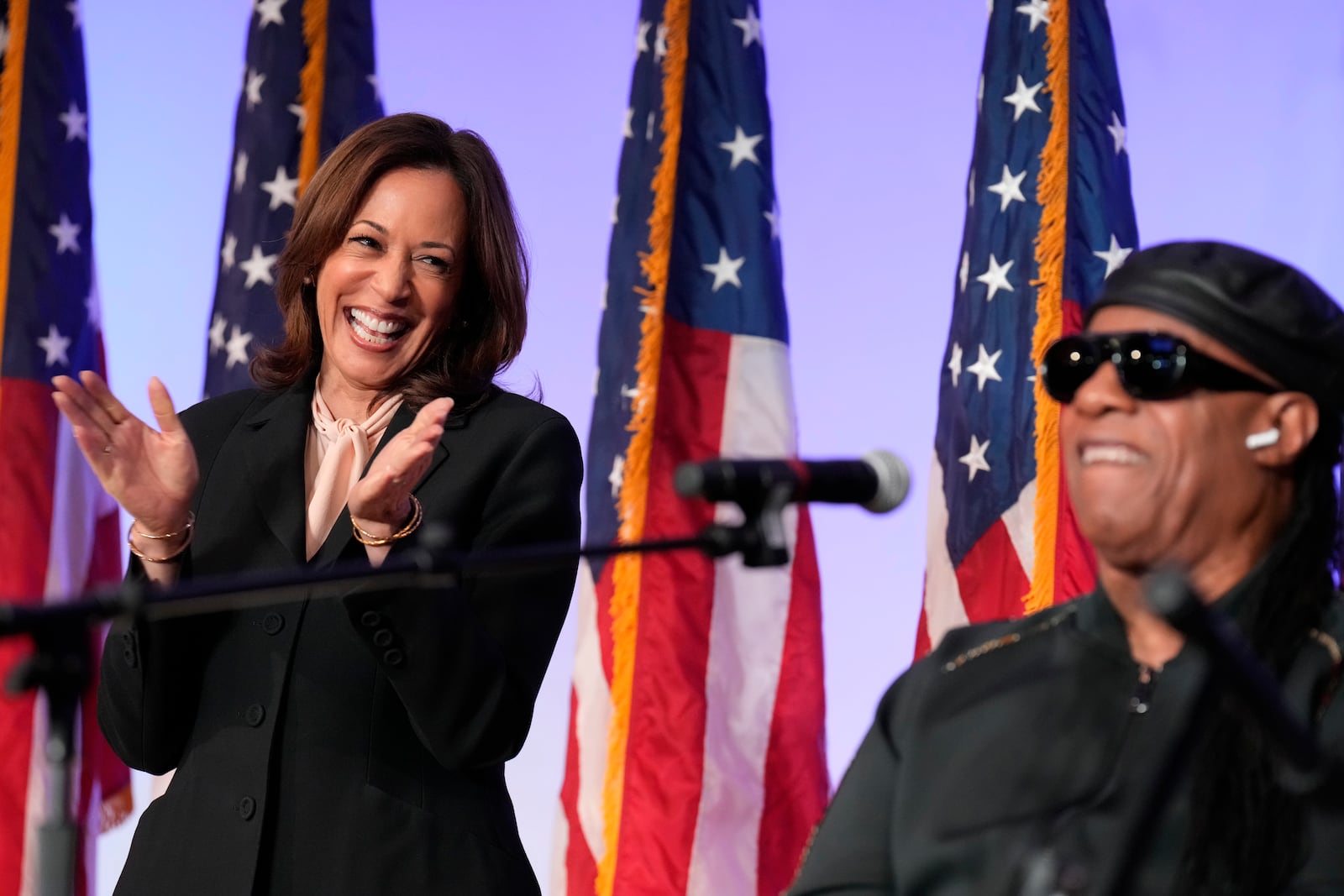 Democratic presidential nominee Vice President Kamala Harris listens as Stevie Wonder performs "Redemption Song" during a church service and early vote event at Divine Faith Ministries International, Sunday, Oct. 20, 2024, in Jonesboro, Ga. (AP Photo/Jacquelyn Martin)