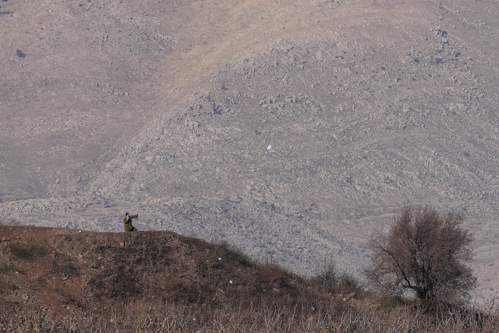 An Israeli soldier flies a kite on the top of a hill along the so-called Alpha Line that separates the Israeli-controlled Golan Heights from Syria, Thursday, Dec. 12, 2024. (AP Photo/Matias Delacroix)