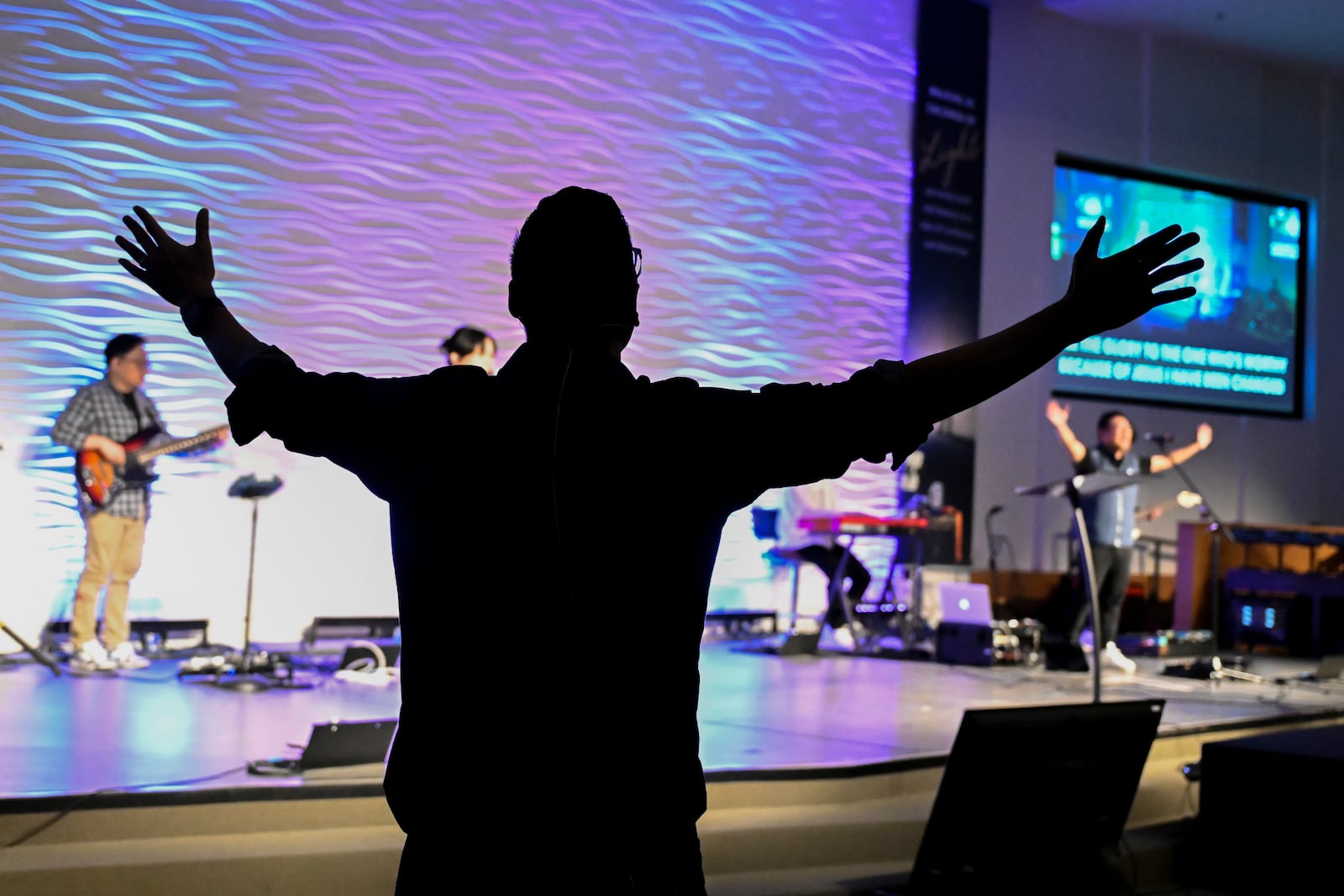 Pastor Owen Lee stretches his arms singing during a service at the Christ Central Presbyterian Church, Sunday, Oct. 13, 2024 in Centreville. (AP Photo/John McDonnell)