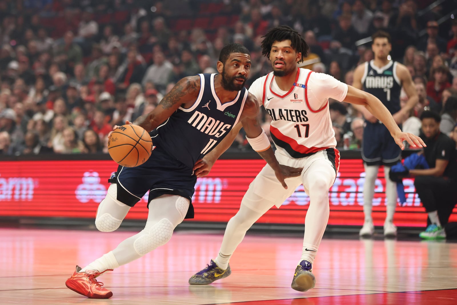 Dallas Mavericks guard Kyrie Irving (11) drives to the basket as Portland Trail Blazers guard Shaedon Sharpe (17) defends during the first half of an NBA basketball game Saturday, Dec. 28, 2024, in Portland, Ore. (AP Photo/Amanda Loman)