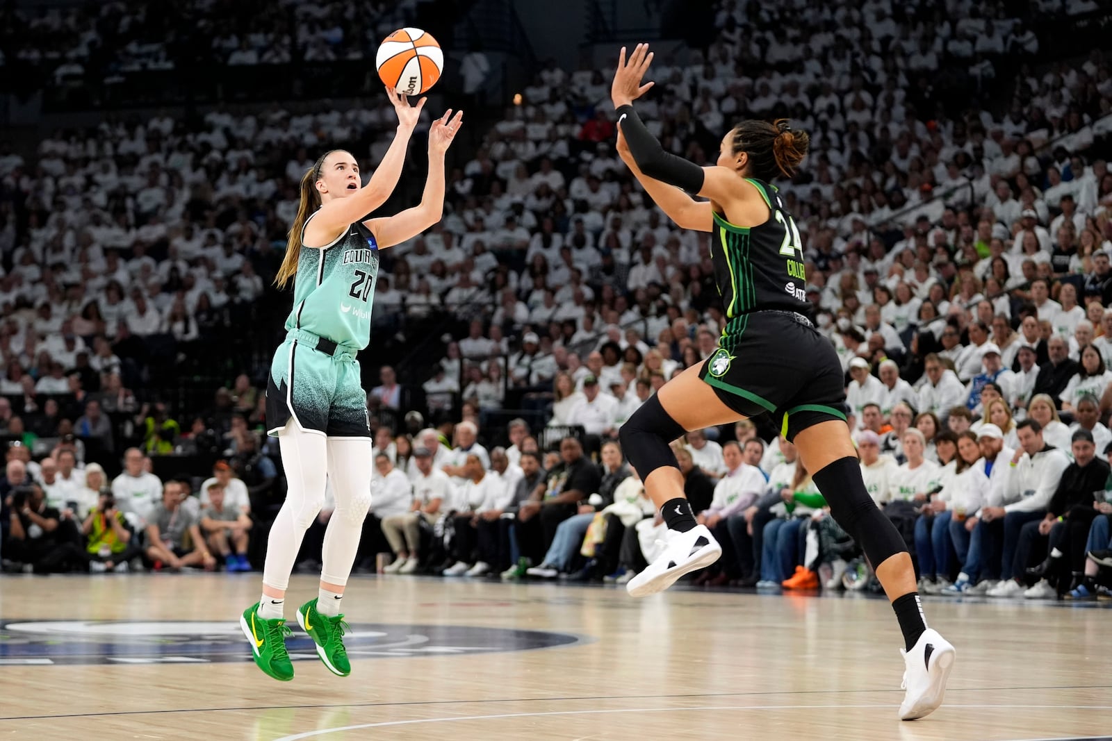 New York Liberty guard Sabrina Ionescu (20) shoots over Minnesota Lynx forward Napheesa Collier, right, during the first half in Game 3 of a WNBA basketball final playoff series, Wednesday, Oct. 16, 2024, in Minneapolis. (AP Photo/Abbie Parr)