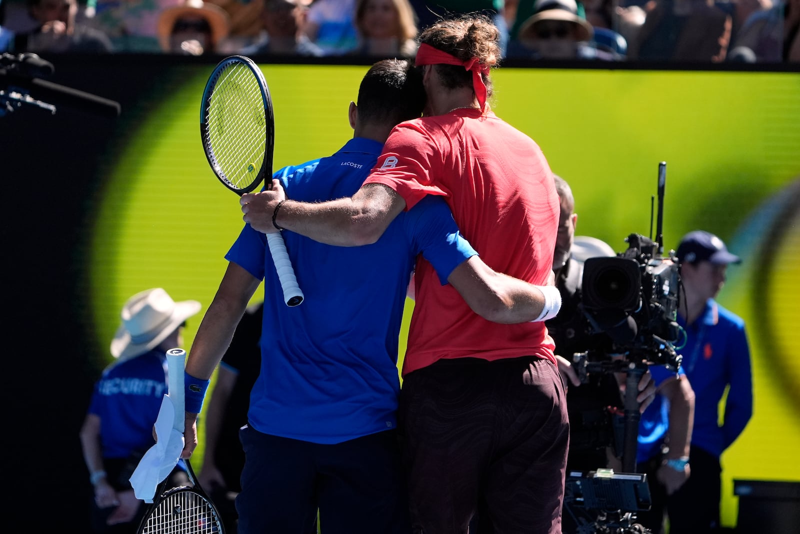 Alexander Zverev, right, of Germany embraces Novak Djokovic of Serbia after Djokovic retired in their semifinal match at the Australian Open tennis championship in Melbourne, Australia, Friday, Jan. 24, 2025. (AP Photo/Asanka Brendon Ratnayake)