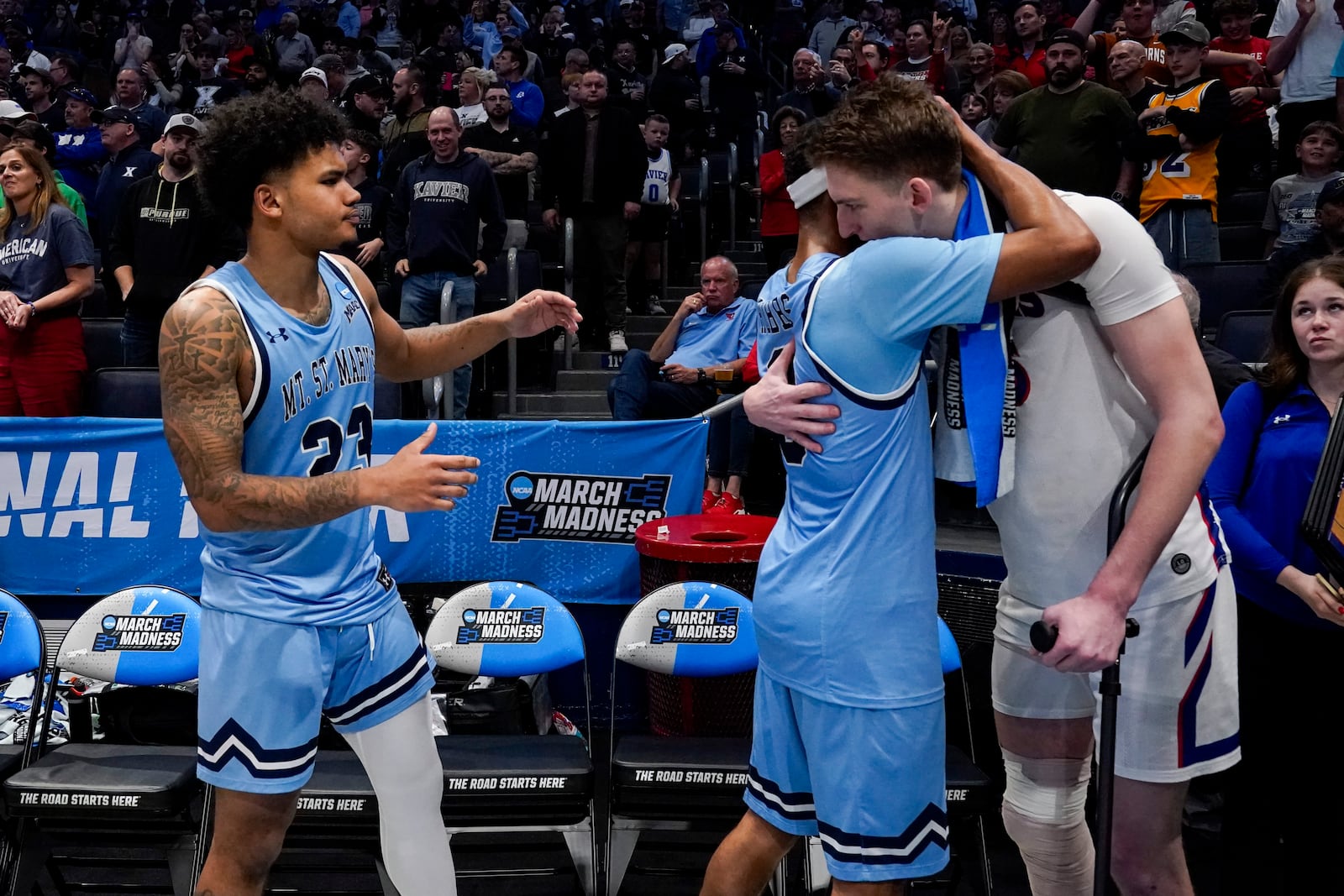 Mount St. Mary's Dallas Hobbs, second from right, embraces American University's Matt Rogers following a First Four college basketball game in the NCAA Tournament, Wednesday, March 19, 2025, in Dayton, Ohio. (AP Photo/Jeff Dean)