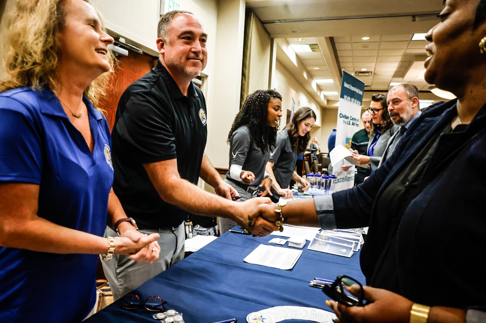 Julie Hagan and Jason Sipe from the Headquarters of the Air Force Materiel Command shake hands with Luciana Moore during an Air Force Research Lab hiring event held at the Fairborn Holiday Inn Tuesday October 8, 2024. JIM NOELKER/STAFF