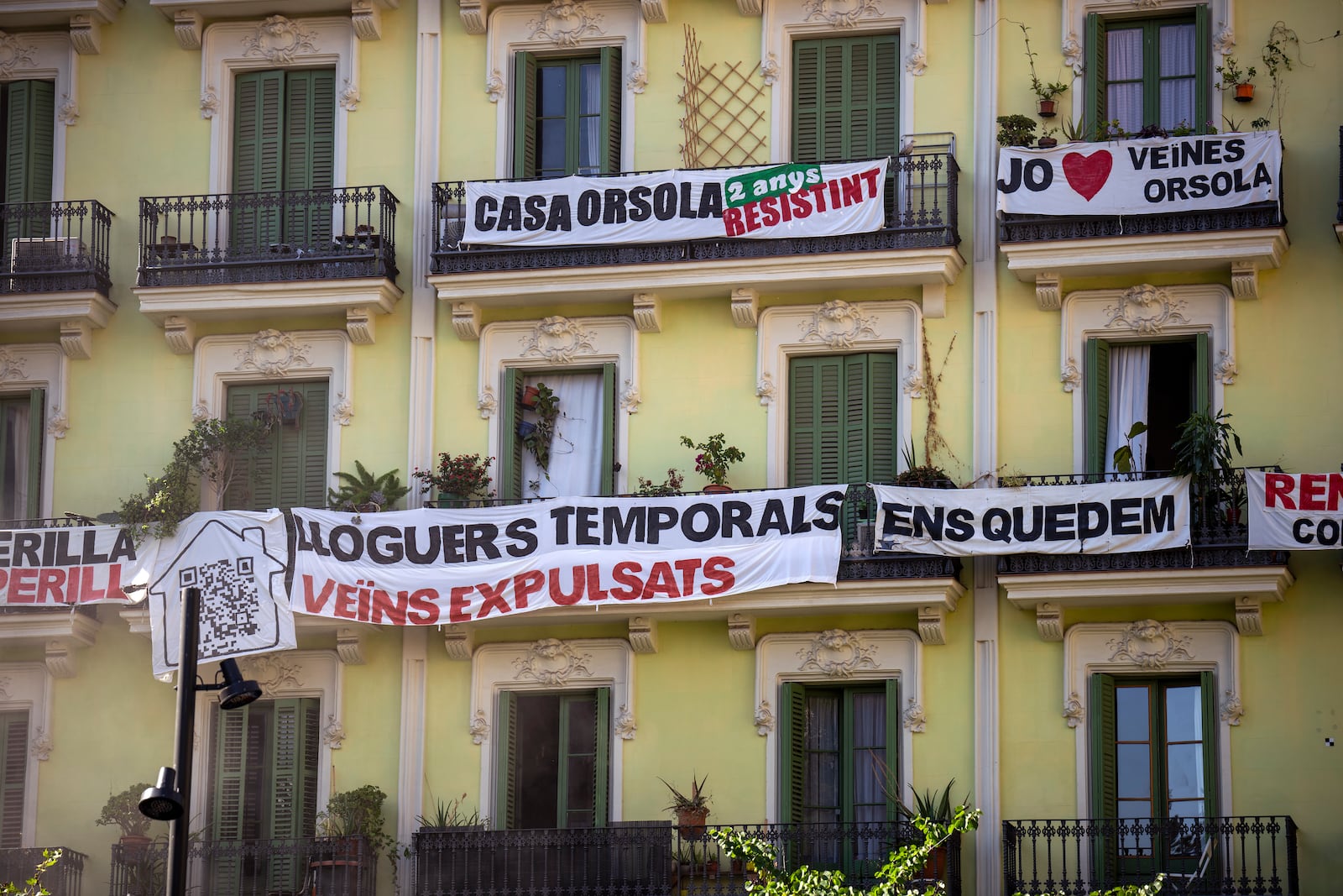 FILE - A block of flats, which is under threat of eviction, is photographed in downtown Barcelona, Spain, Wednesday, July 10, 2024.The banner in the center reads in Catalan: "temporary rental housing: neighbours evicted". (AP Photo/Emilio Morenatti, File)