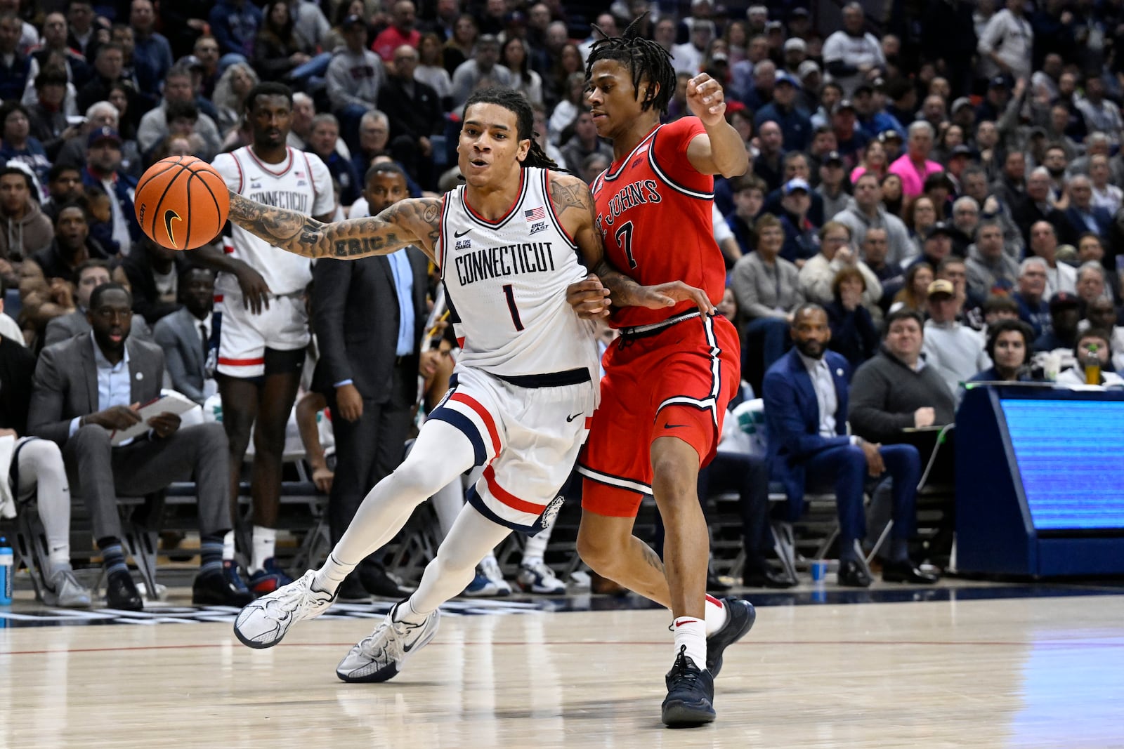 UConn guard Solo Ball (1) is guarded by St. John's guard Simeon Wilcher (7) in the second half of an NCAA college basketball game, Friday, Feb. 7, 2025, in Storrs, Conn. (AP Photo/Jessica Hill)