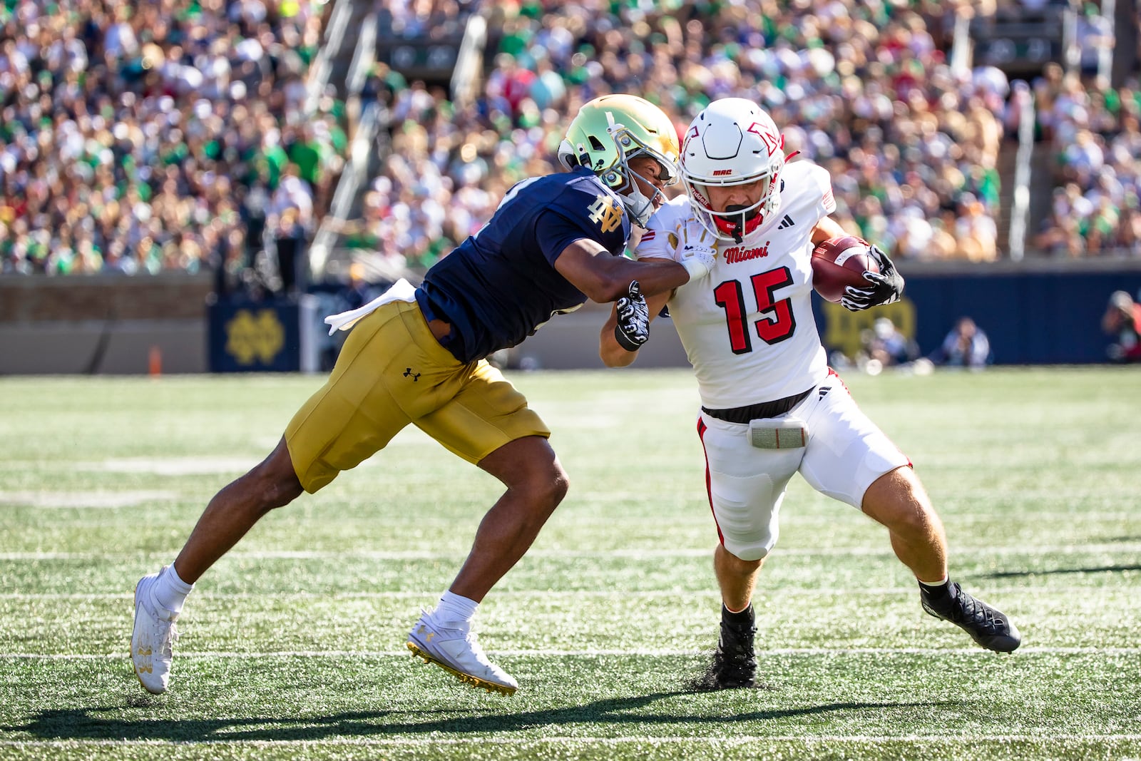 Miami (Ohio) wide receiver Cade McDonald (15) runs with the ball as Notre Dame safety Rod Heard II, left, pushes him during the first half of an NCAA college football game Saturday, Sept. 21, 2024, in South Bend, Ind. (AP Photo/Michael Caterina)