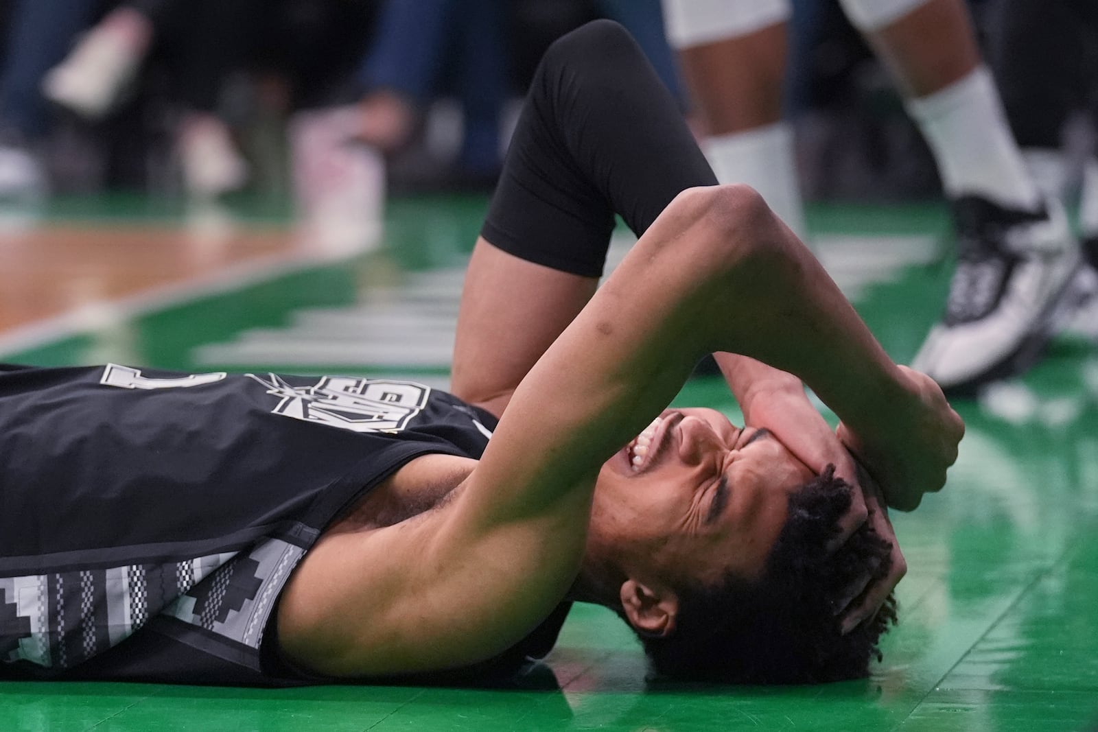 San Antonio Spurs center Victor Wembanyama grabs his head after getting knocked to the floor against the Boston Celtics during the first half of an NBA basketball game, Wednesday, Feb. 12, 2025, in Boston. (AP Photo/Charles Krupa)