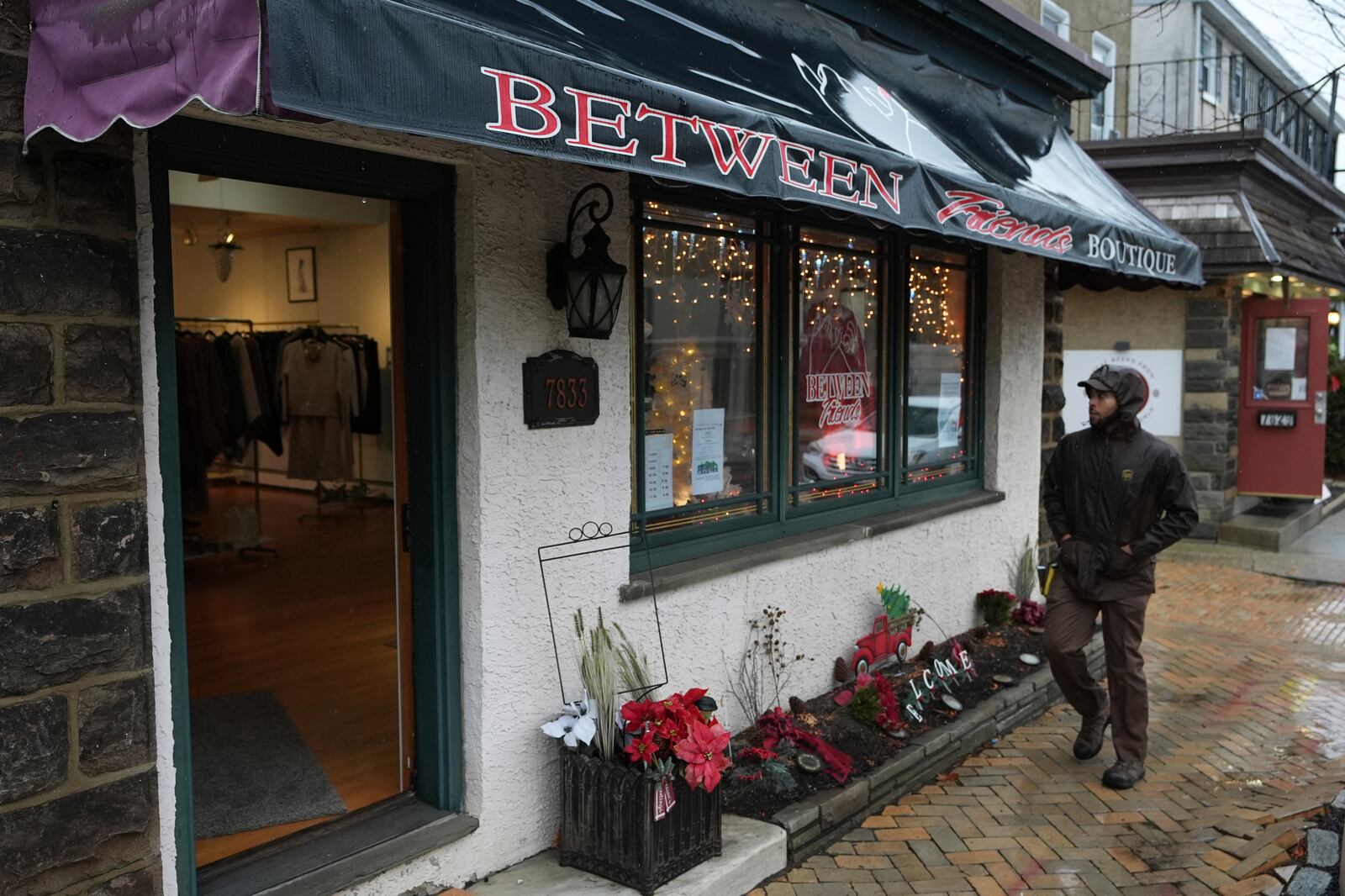 A person walks past Between Friends Boutique, Wednesday, Dec. 11, 2024, in Philadelphia. (AP Photo/Matt Slocum)