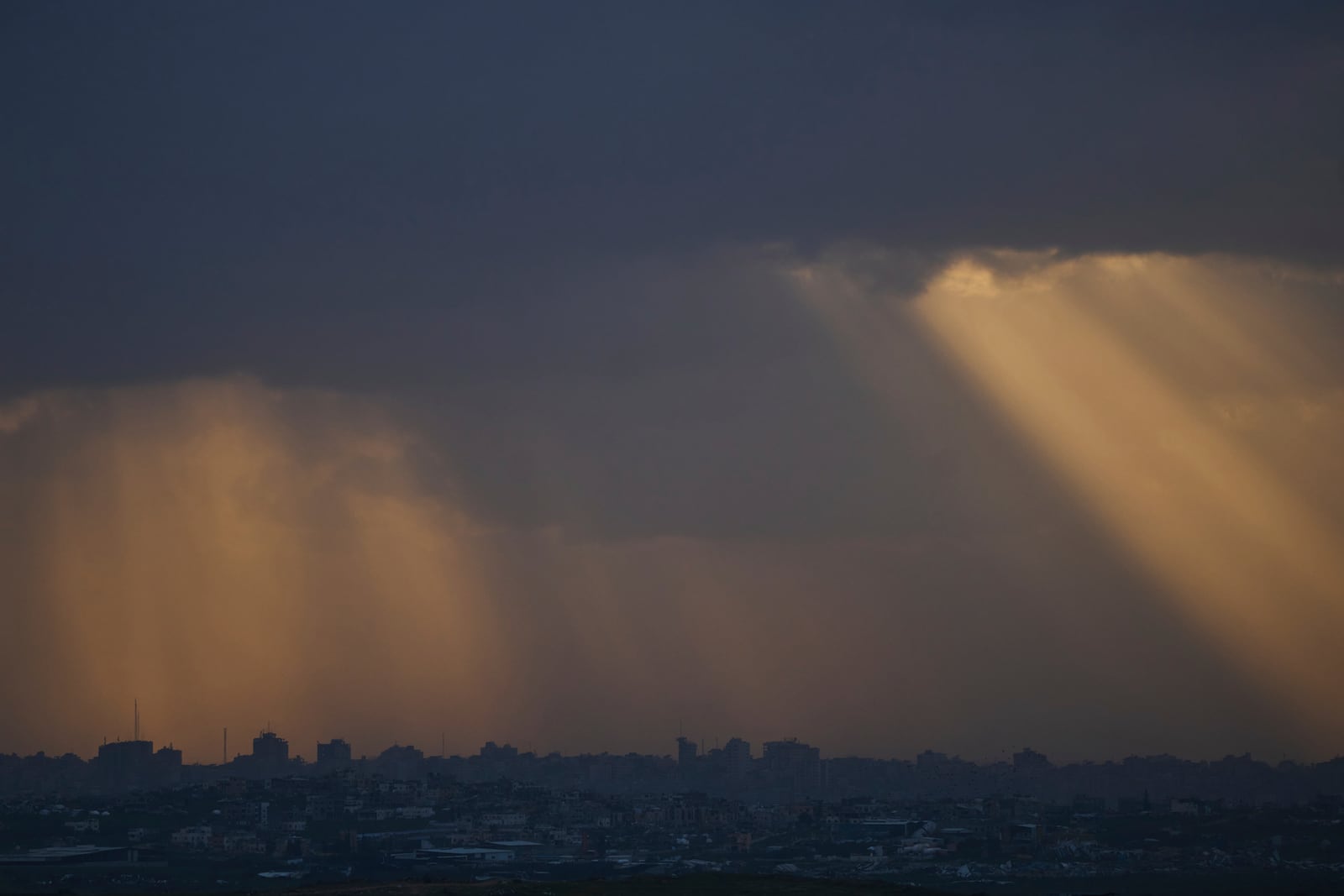 Buildings destroyed during the Israeli attack are seen in the Gaza Strip during the sunset as seen from southern Israel, Thursday, March 20, 2025. (AP Photo/Leo Correa)