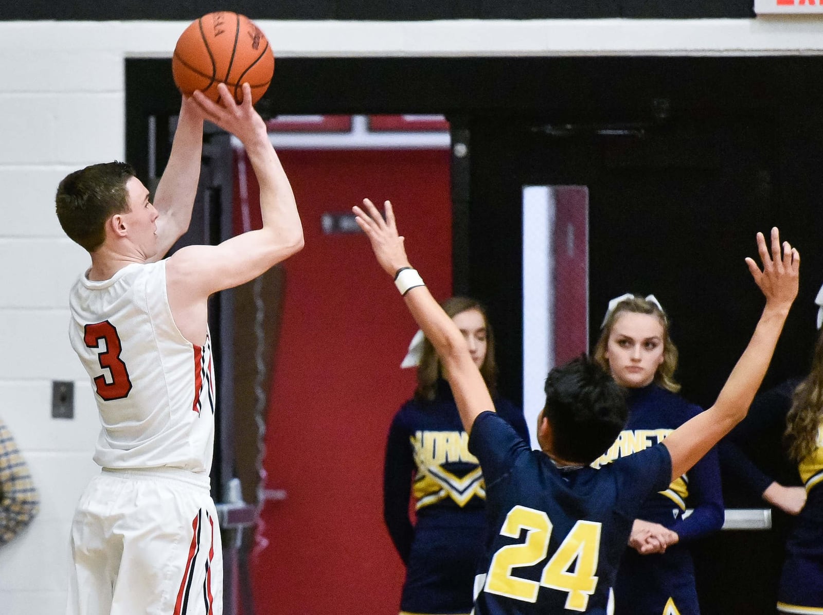 Franklin’s Zack Minton puts up a shot over Monroe’s Marty Zumbiel on Friday night at Darrell Hedric Gym in Franklin. NICK GRAHAM/STAFF