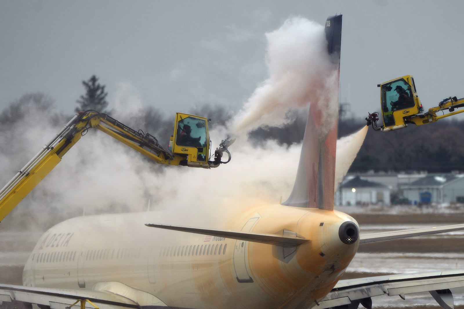 A Delta Air Lines jet is deiced before takeoff at the Detroit Metropolitan Wayne County Airport in Romulus, Mich., Monday, Jan. 6, 2025. (AP Photo/Charlie Riedel)