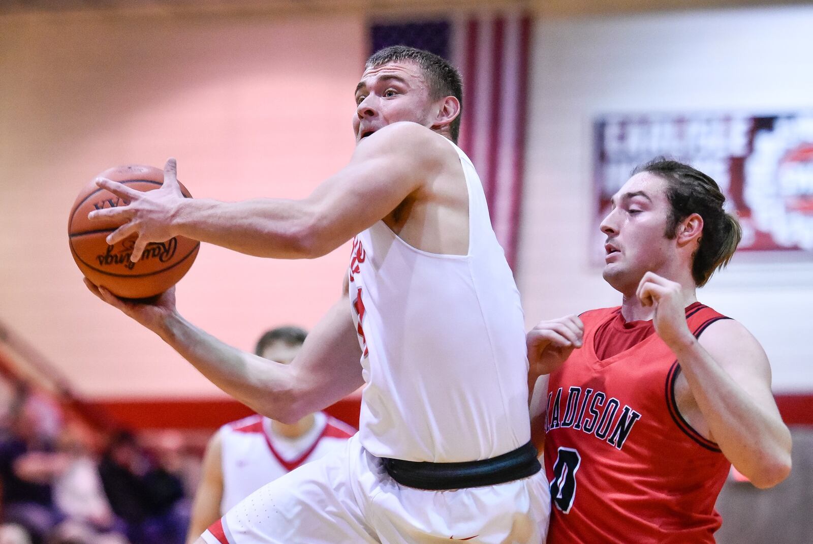 Carlisle’s Dane Flatter drives to the hoop defended by Madison’s Matt Gomia during Friday night’s game at Carlisle. Visiting Madison won 58-39. NICK GRAHAM/STAFF