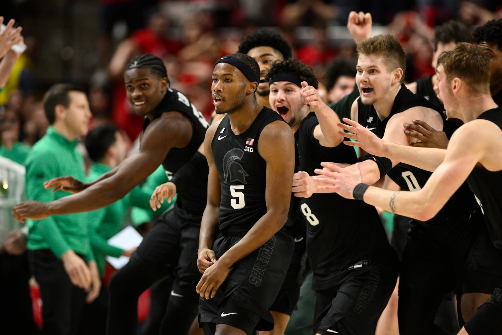 Michigan State guard Tre Holloman (5) and teammates celebrate after he made a game-winning basket to win the game at the buzzer during the second half of an NCAA college basketball game against Maryland, Wednesday, Feb. 26, 2025, in College Park, Md. (AP Photo/Nick Wass)