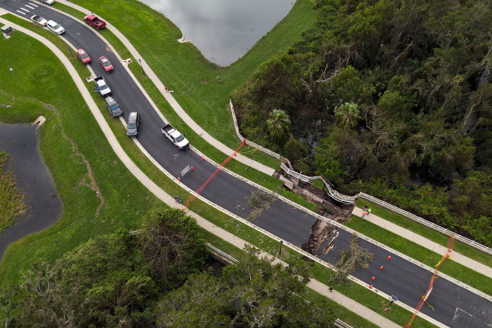 A sink hole is visible on a road damaged by Hurricane Milton, Friday, Oct. 11, 2024, in Riverview, Fla. The road is the only access point into a community. (AP Photo/Julio Cortez)