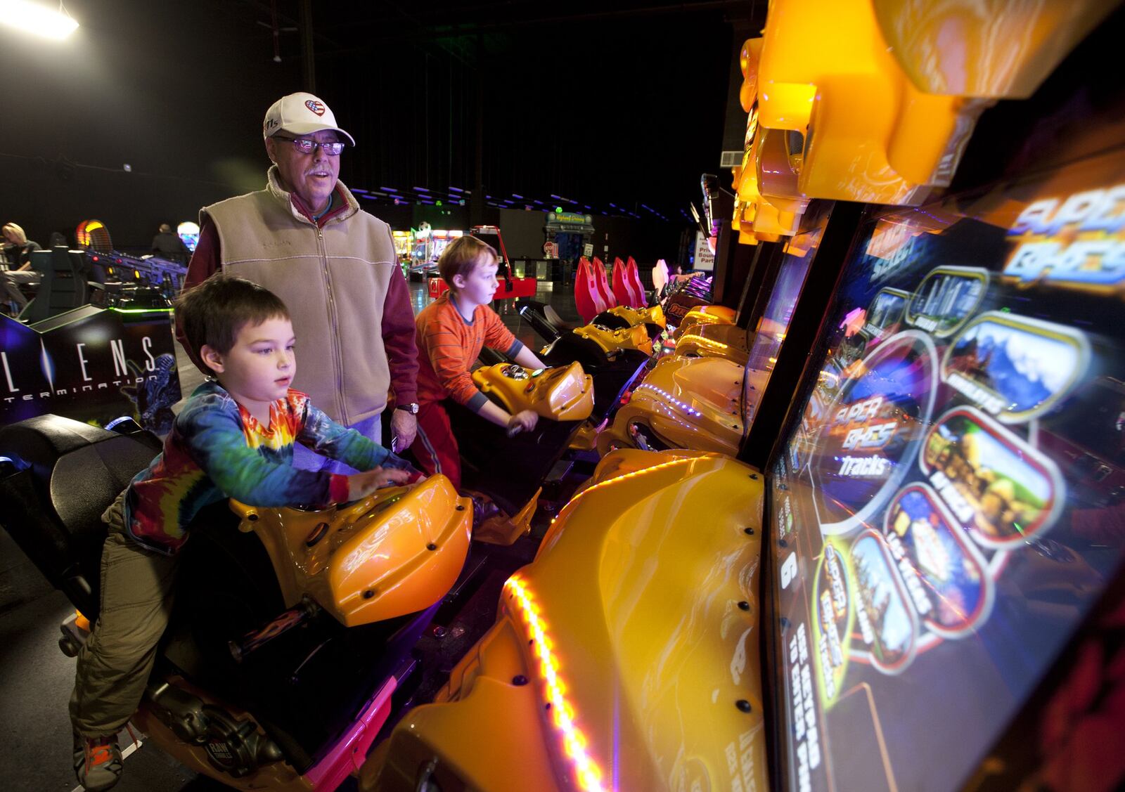 Rick Jackson from Troy supervises his grandsons as they ride the video motorcycle games at Scene 75. TY GREENLEES/STAFF