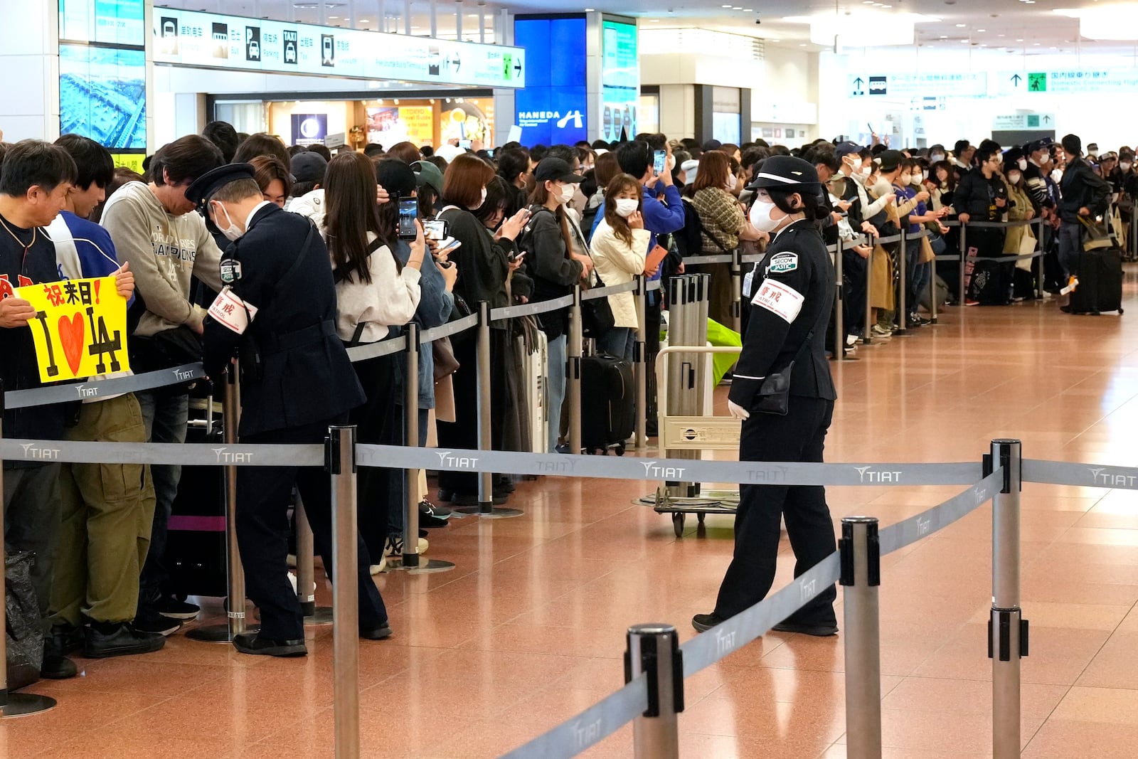 Fans of Los Angeles Dodgers wait for the team arrival at Tokyo International Airport Thursday, March 13, 2025, in Tokyo, as Dodgers is scheduled to play their MLB opening games against Chicago Cubs in Tokyo on March 18-19. (AP Photo/Hiro Komae)