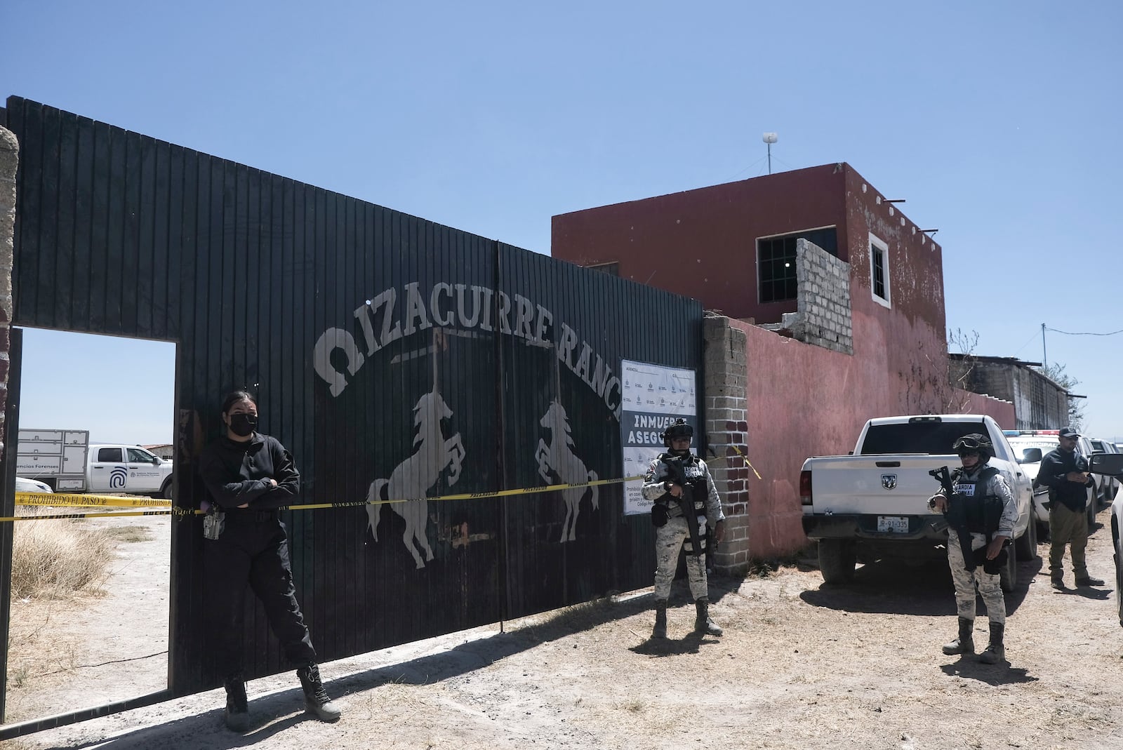 Police stand guard outside the entrance to Izaguirre Ranch where skeletal remains were discovered in Teuchitlan, Jalisco state, Mexico, Thusday, March 13, 2025. (AP Photo/Alejandra Leyva)