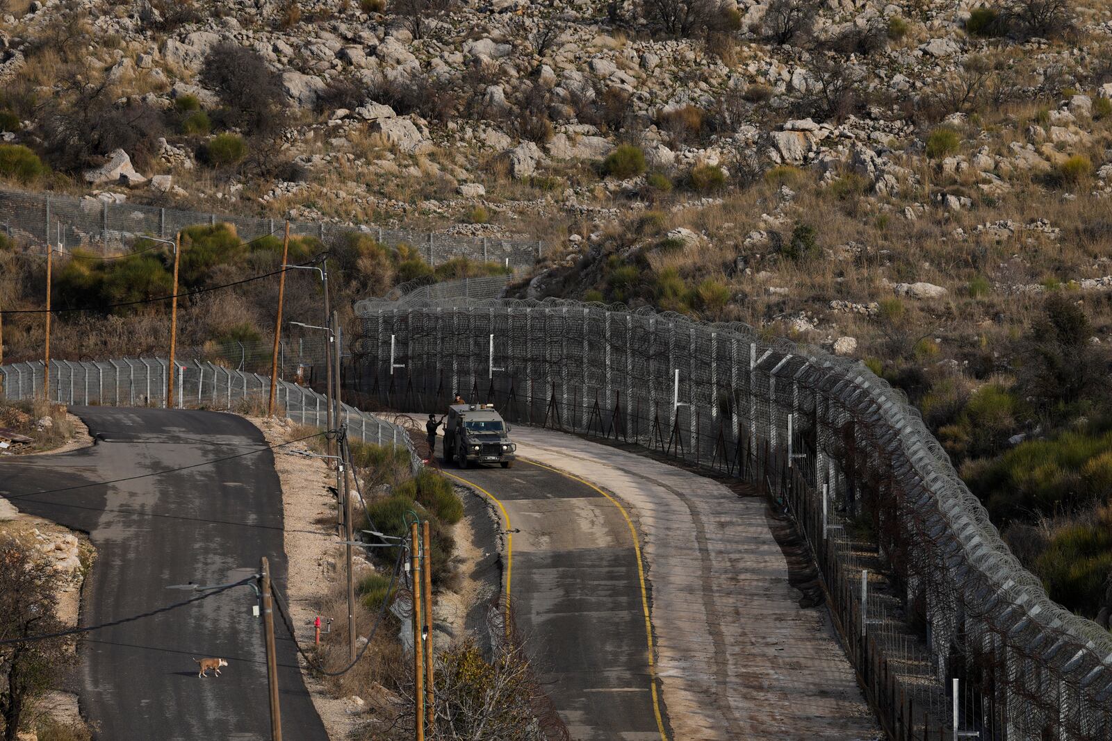 Israeli soldiers stand next to an armoured vehicle before crossing the security fence, moving towards the so-called Alpha Line that separates the Israeli-controlled Golan Heights from Syria, in the town of Majdal Shams, Friday, Dec. 20, 2024. (AP Photo/Matias Delacroix)