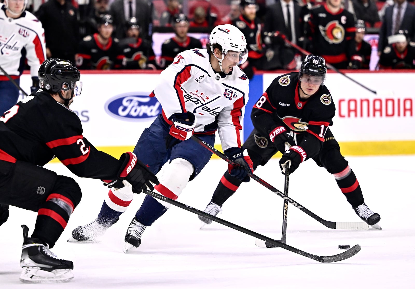 Washington Capitals' Dylan Strome (17) tries to get away from Ottawa Senators' Tim Stutzle (18) and Artem Zub (2) during first-period NHL hockey game action in Ottawa, Ontario, Thursday, Jan. 30, 2025. (Justin Tang/The Canadian Press via AP)