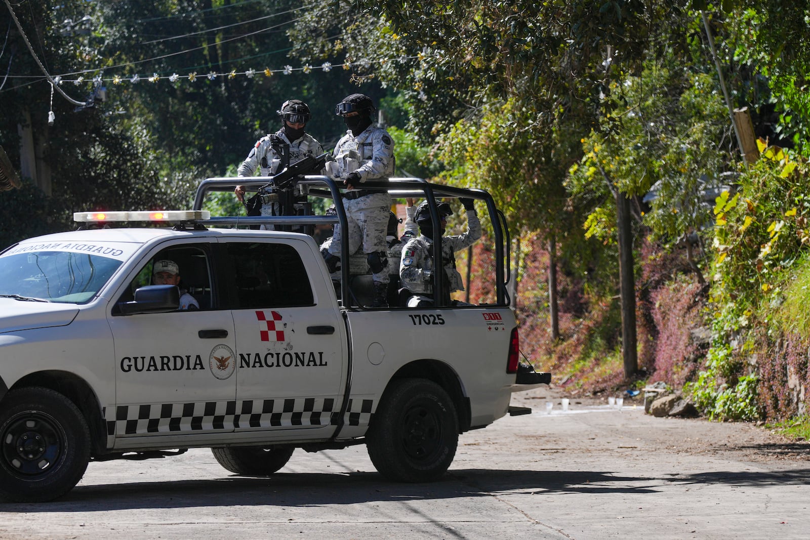 Members of Mexico's National Guard patrol the streets where five people were killed the day before, in Huitzilac, Mexico, Tuesday, Jan. 14, 2025. (AP Photo/Fernando Llano)