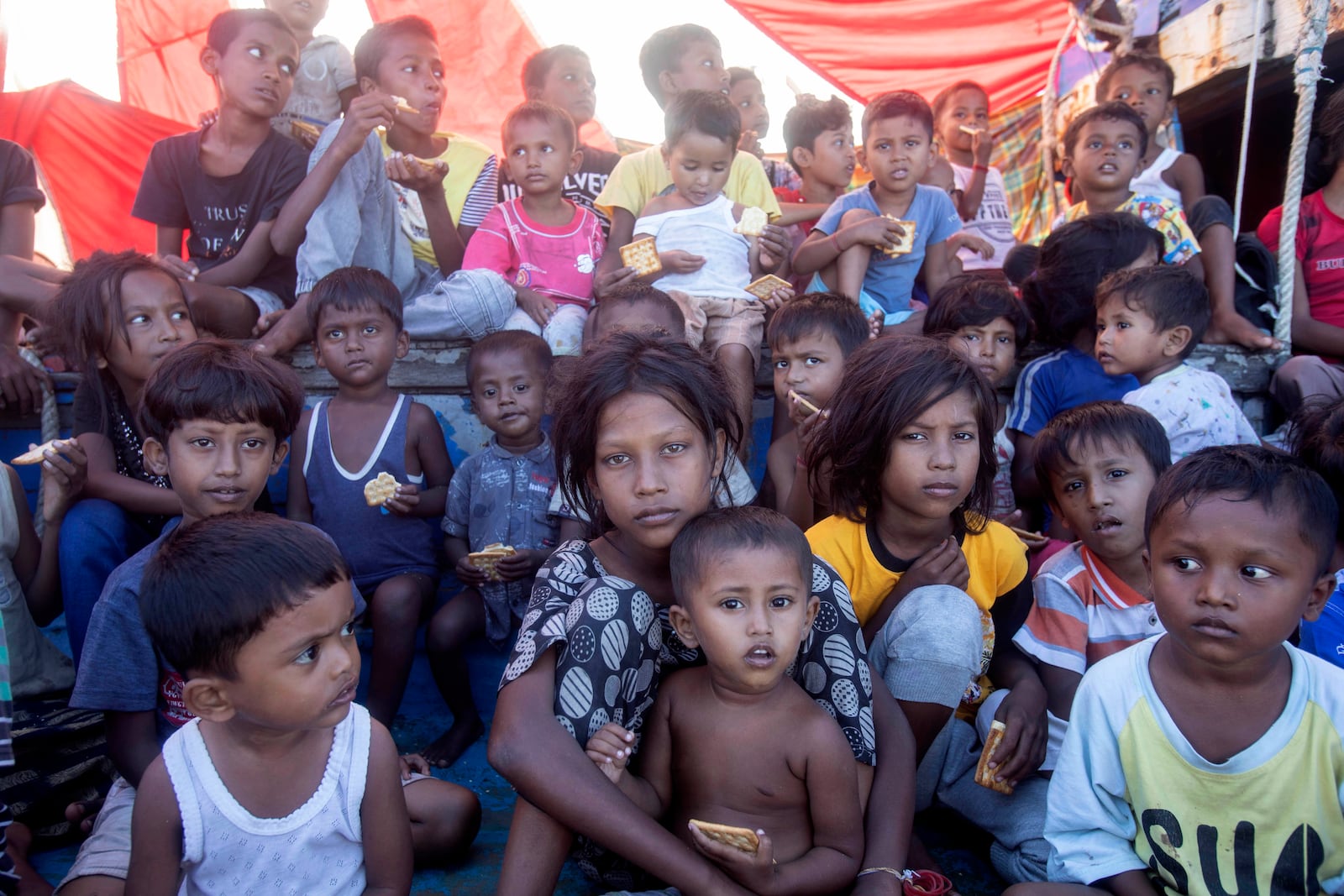 Rohingya refugee children sit on the deck of their boat anchored in the waters near the coast of Labuhan Haji, Aceh province, Indonesia, Tuesday, Oct. 22, 2024. (AP Photo/Binsar Bakkara)