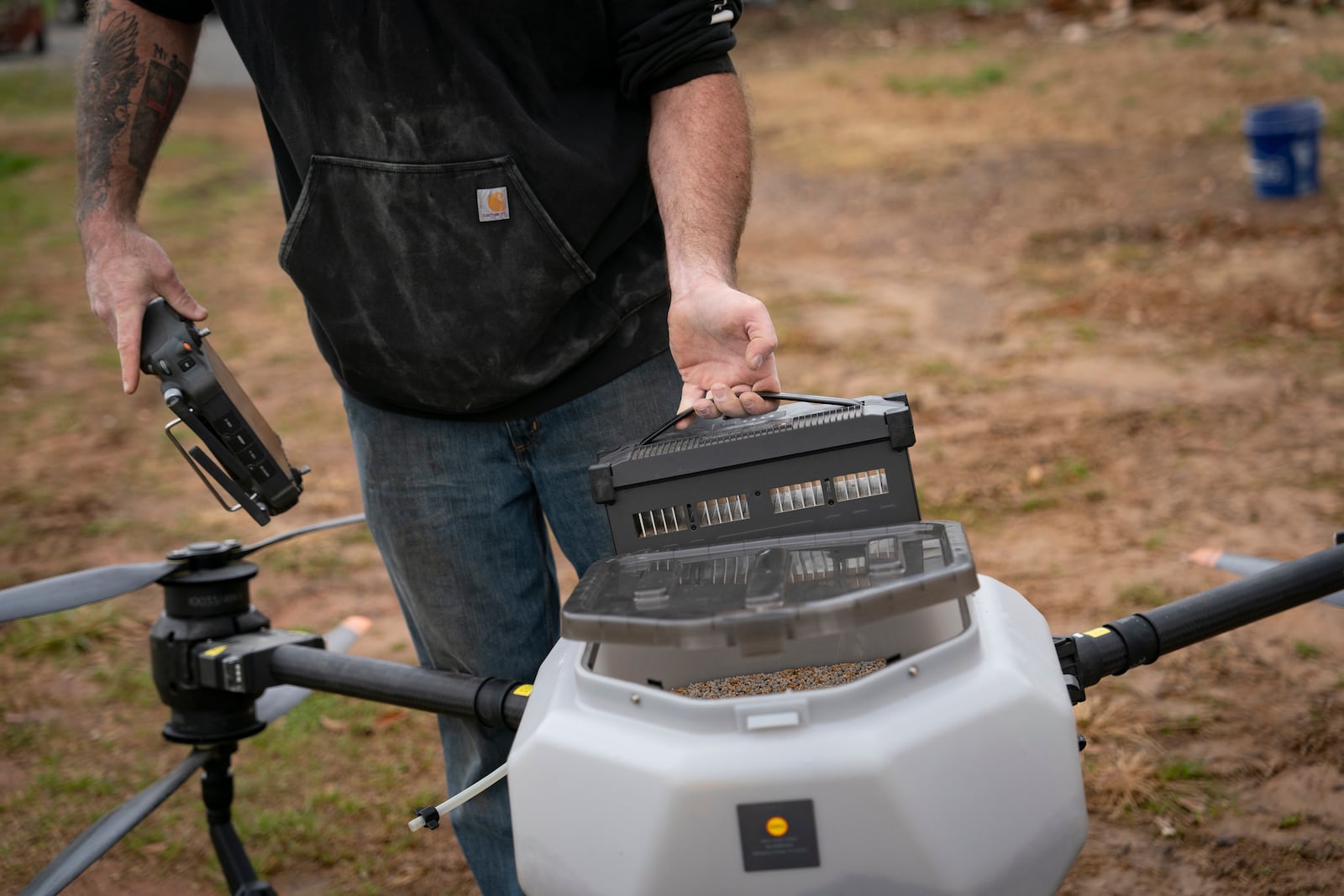 Russell Hedrick puts a battery in a DJI drone to put crop cover on his farm, Tuesday, Dec. 17, 2024, in Hickory, N.C. (AP Photo/Allison Joyce)