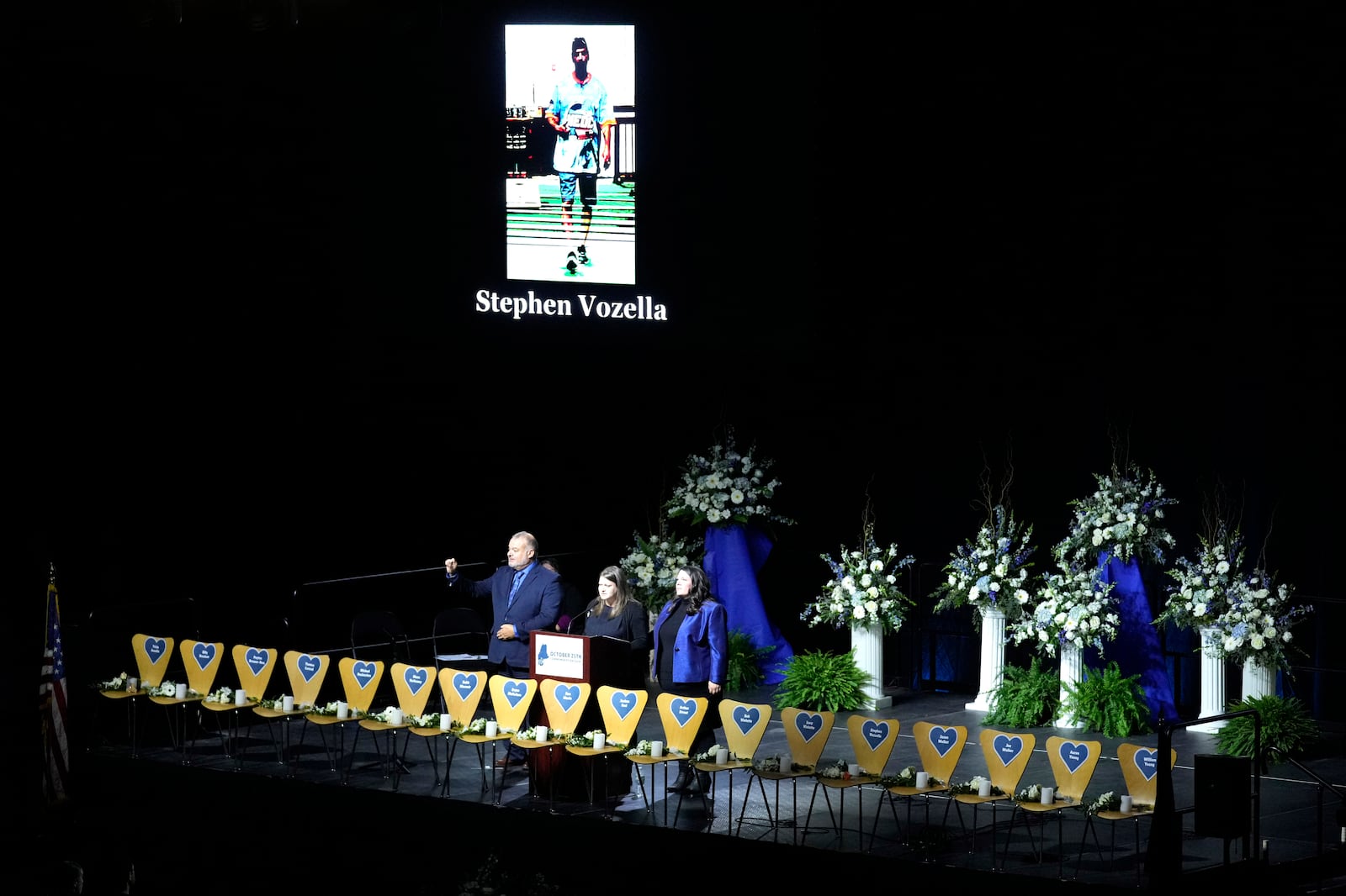 Empty chairs stand for each of the 18 victims as their names are read out loud at a commemoration event to mark the one year anniversary of the mass shooting in Lewiston, Maine, Friday, Oct. 25, 2024. (AP Photo/Robert F. Bukaty)