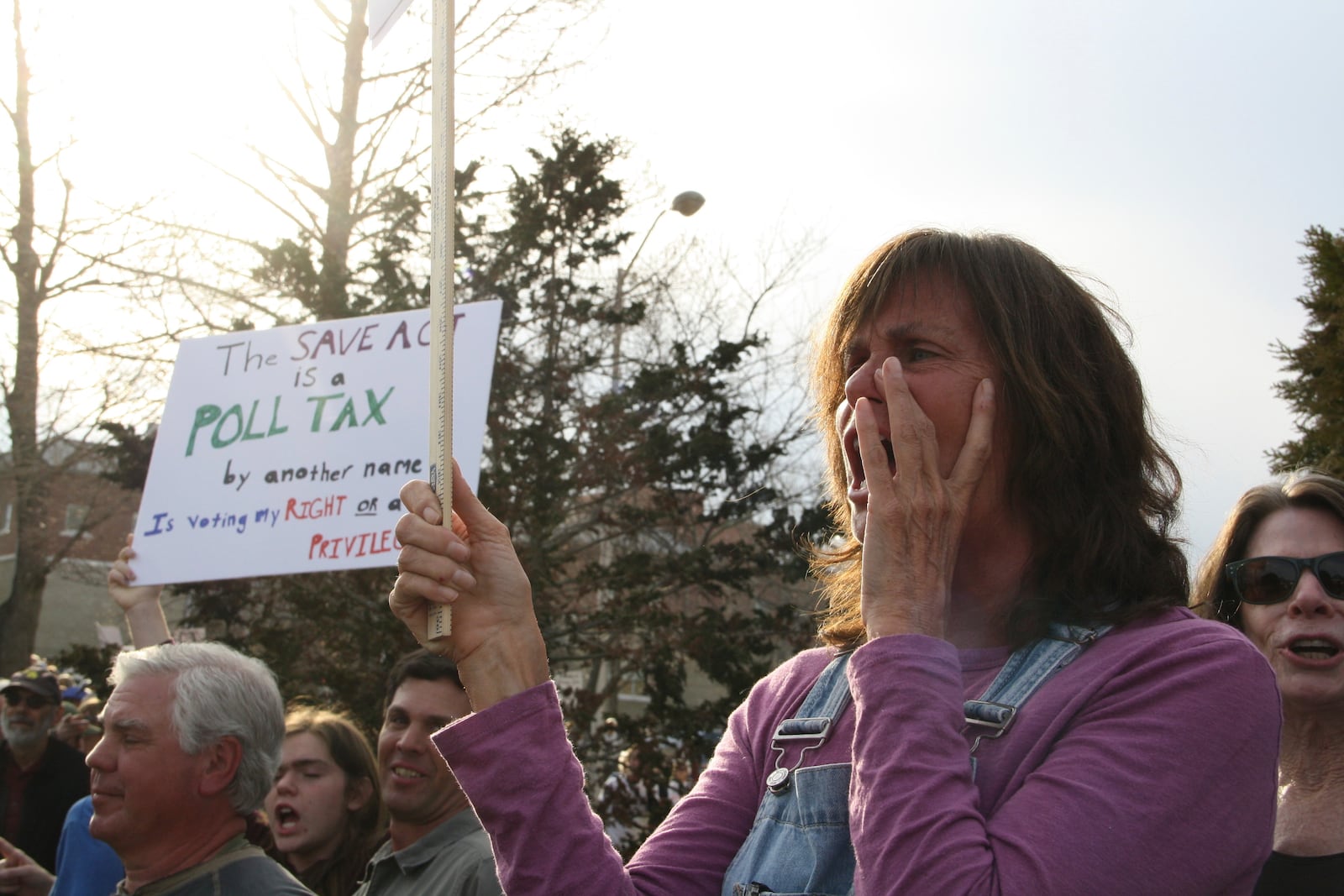 A protester holds a sign outside a town hall holds by Rep. Chuck Edwards in Asheville, N.C. on Thursday, March 13, 2025. (AP Photo/Makiya Seminera)