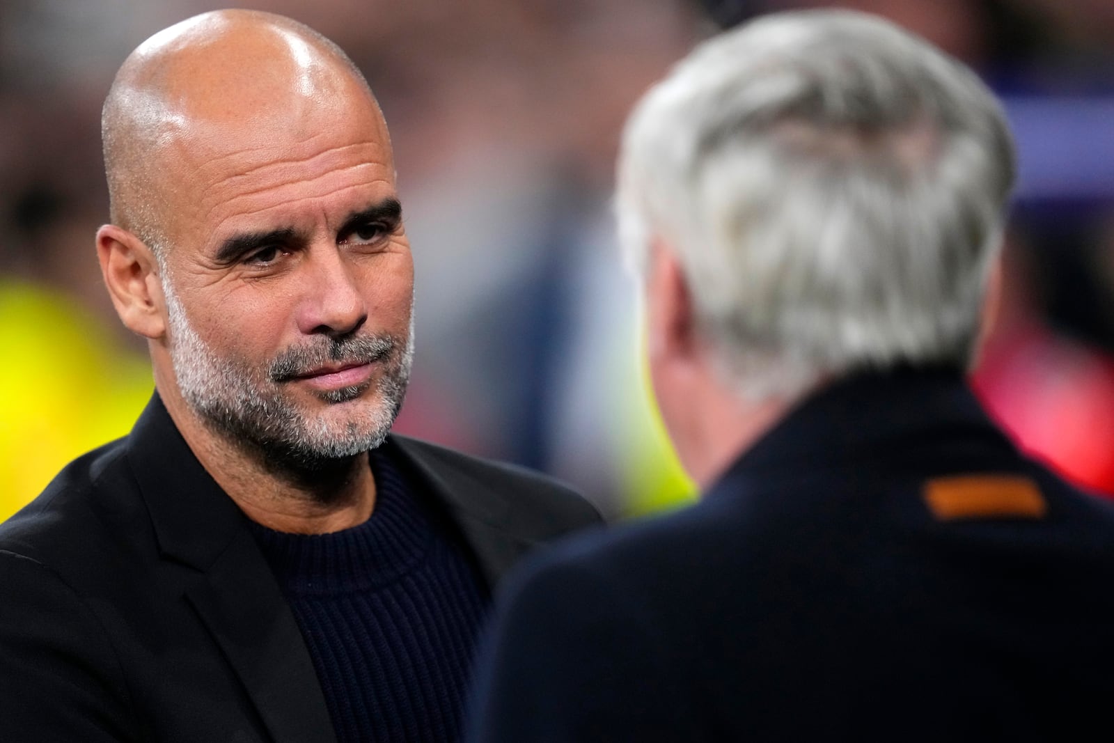 Manchester City's head coach Pep Guardiola, left, greets Real Madrid's head coach Carlo Ancelotti during the Champions League playoff second leg soccer match between Real Madrid and Manchester City at the Santiago Bernabeu Stadium in Madrid, Spain, Wednesday, Feb. 19, 2025. (AP Photo/Manu Fernandez)