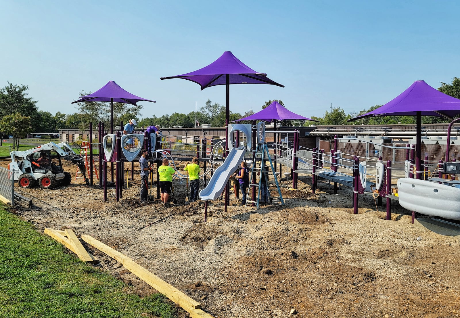 The playground at Amanda Elementary School on Oxford-State Road nears completion on Monday after four days of work from Middletown Kiwanis members and community volunteers. The playground will be named in memory of Guy Stone, a longtime Kiwanian and co-chair of the project who died this year. NICK GRAHAM/STAFF