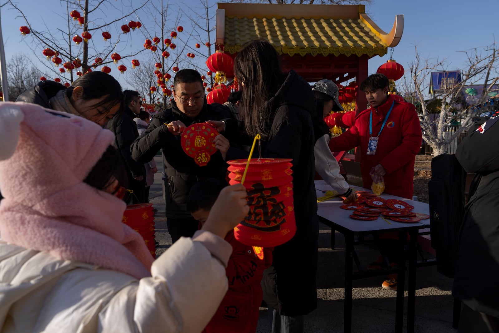 Visitors collect free lanterns at a Lantern Festival during Yuanxiao, the fifteen day of the Lunar New Year in Beijing, Wednesday, Feb. 12, 2025. (AP Photo/Ng Han Guan)