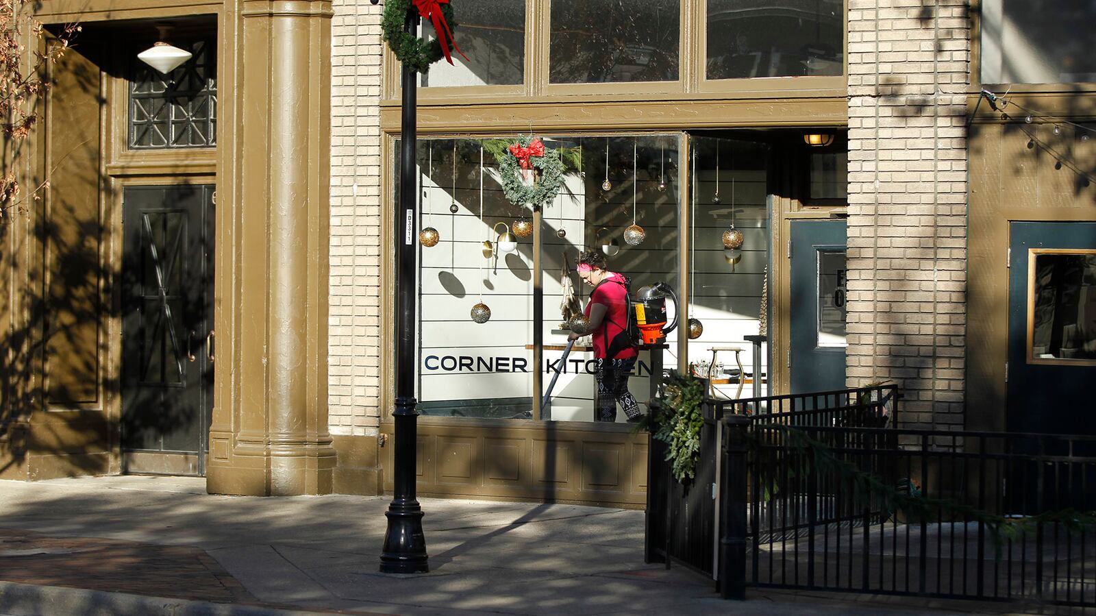 Liddy Vella vacuums the dining area of the Corner Kitchen at the corner of E. Fifth St. and Wayne Avenue.  TY GREENLEES / STAFF