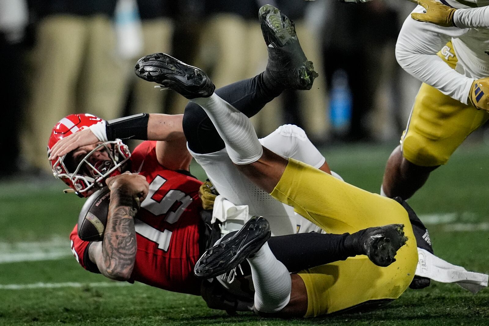 Georgia quarterback Carson Beck (15) is sacked by Georgia Tech linebacker Tah'j Butler (15) during the first half of an NCAA college football game, Friday, Nov. 29, 2024, in Athens, Ga. (AP Photo/Mike Stewart)