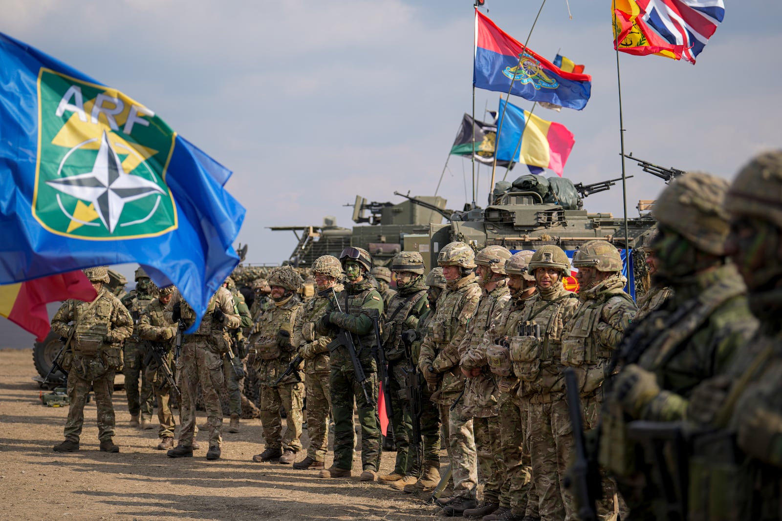 Servicemen stand at the end of the Steadfast Dart 2025 exercise, involving some 10,000 troops in three different countries from nine nations and represent the largest NATO operation planned this year, at a training range in Smardan, eastern Romania, Wednesday, Feb. 19, 2025. (AP Photo/Vadim Ghirda)