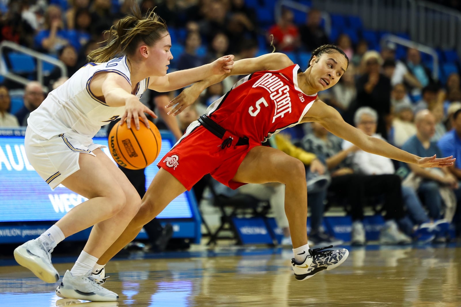 UCLA guard Elina Aarnisalo (7) dribbles against Ohio State guard Ava Watson (5) during the first half of an NCAA college basketball game Wednesday, Feb. 5, 2025, in Los Angeles. (AP Photo/Jessie Alcheh)